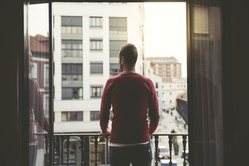 Man on a balcony in the city at sunset - EPF00389