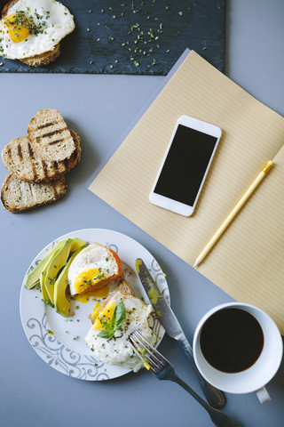 Having a food break while studying: eggs, avocado, bread and coffee stock photo