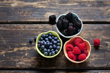 Bowls of blackberries, blueberries and rapsberries on dark wood - CSF28000