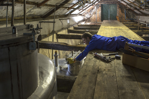 Arbeiter bei der Reparatur von Tanks in einer Whiskey-Destillerie, lizenzfreies Stockfoto