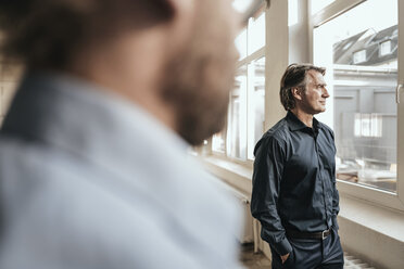 Mature businessman looking out of window - JOSF00669