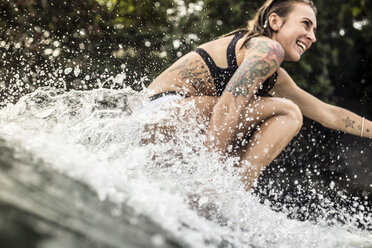 Indonesien, Java, glückliche Frau beim Surfen - KNTF00687