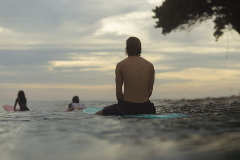 Indonesien, Java, Surfer auf Surfbrett auf dem Meer warten auf eine Welle - KNTF00692