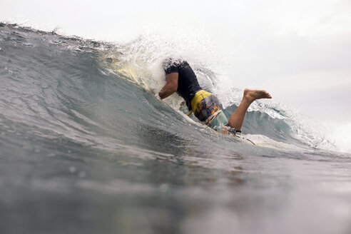 Indonesien, Java, Wasser spritzt über Mann beim Surfen - KNTF00704