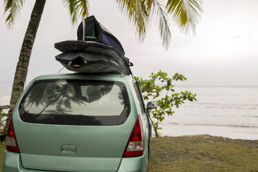 Indonesia, Java, car with surfboards on the roof at the coast - KNTF00727