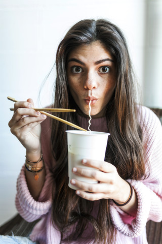Junge Frau isst chinesische Nudeln, lizenzfreies Stockfoto