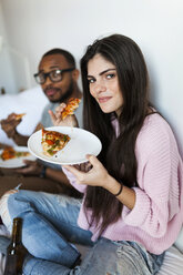 Young couple sitting at home eating pizza - VABF01250