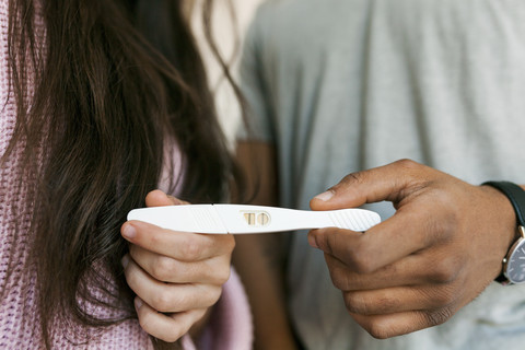 Junges Paar mit positivem Schwangerschaftstest, lizenzfreies Stockfoto