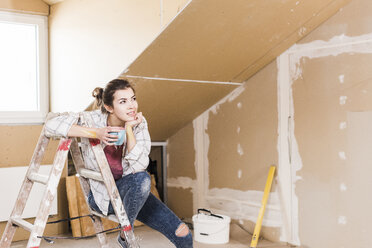 Young woman contemplating the renovation of her new home - UUF10084