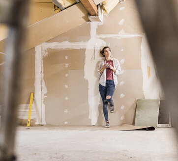 Young woman contemplating the renovation of her new home - UUF10085