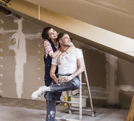 Young couple on construction site of their new home - UUF10112