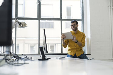 Junger Geschäftsmann im Büro mit digitalem Tablet - SBOF00299