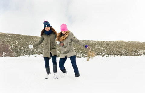 Zwei Freunde haben Spaß im Schnee, lizenzfreies Stockfoto