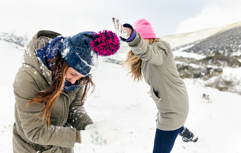 Schneeballschlacht unter Freunden im Schnee, lizenzfreies Stockfoto