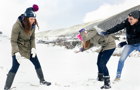Schneeballschlacht unter Freunden im Schnee, lizenzfreies Stockfoto