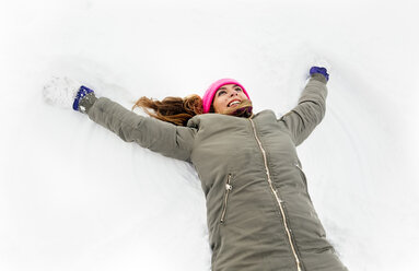 Young woman making a snow angel - MGOF03045