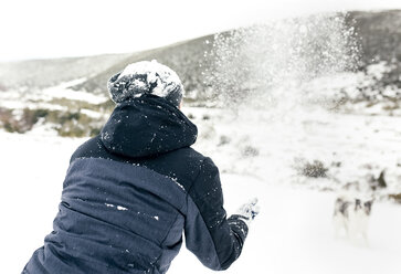 Young man playing with his dog in the snow - MGOF03053