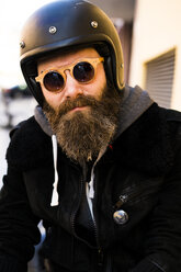 Porträt eines bärtigen Motorradfahrers mit Helm und Sonnenbrille - KKAF00493