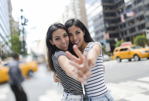 USA, New York City, portrait of two beautiful twin sisters in Manhattan having fun stock photo