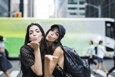 USA, New York City, zwei Zwillingsschwestern, die sich in Manhattan einen Kuss geben - GIOF02223