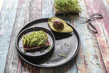 Slice of bread with beetroot hummus, slices of avocado and cress - SARF03256