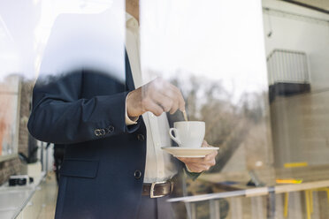 Geschäftsmann mit Tasse Kaffee am Fenster - KNSF01159