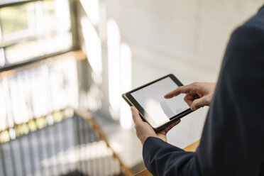 Businessman using tablet in staircase - KNSF01167