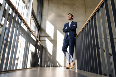 Businessman standing in staircase - KNSF01172