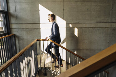 Businessman walking up stairs - KNSF01180