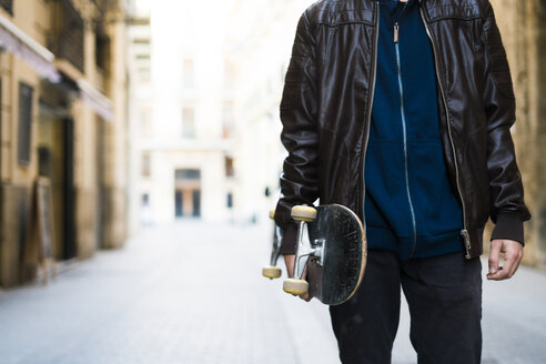 Junger Mann mit Skateboard in der Stadt - KKAF00501