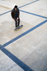 Young man riding skateboard on a square - KKAF00503