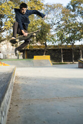 Young man riding skateboard in a skatepark - KKAF00509