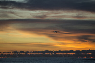 Indonesia, Bali, airplane in the sky and sunset over the ocean - KNTF00747