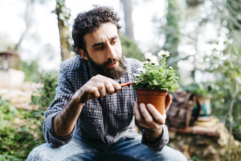 Mann beschneidet Blume in seinem Garten - JRFF01264