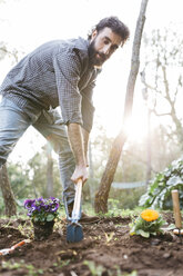 Mann pflanzt Blumen in seinem Garten - JRFF01274