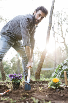 Mann pflanzt Blumen in seinem Garten - JRFF01274