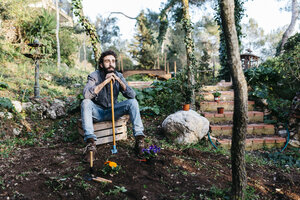 Mann im Garten, der eine Pause von der Gartenarbeit macht - JRFF01276