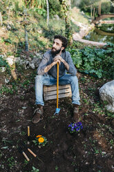 Man in garden having a break from gardening - JRFF01278