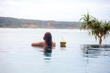 Indonesien, Insel Lombok, Frau im Infinity-Pool - KNTF00759