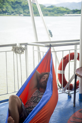 Indonesia, Lombok island, man lying in hammock on ship deck stock photo