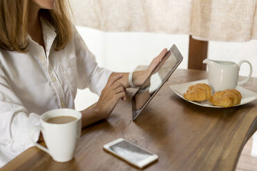 Frau am Frühstückstisch mit Tablet - KNTF00781