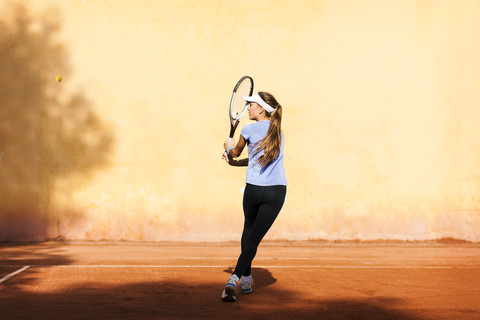 Teenager-Mädchen spielt Tennis auf dem Platz, lizenzfreies Stockfoto