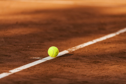 Tennis ball hitting the line on clay court stock photo