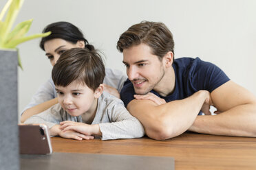 Familie zu Hause mit Blick auf das Mobiltelefon - SHKF00726