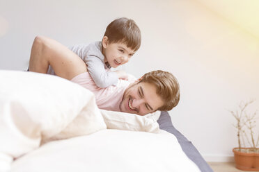 Glücklicher Vater und Sohn spielen im Bett - SHKF00734