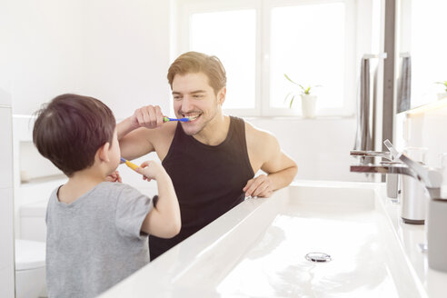 Vater und Sohn beim gemeinsamen Zähneputzen im Badezimmer - SHKF00741
