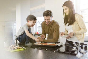 Familie bereitet gemeinsam Pizza in der Küche zu - SHKF00753