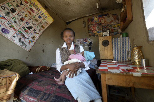 Madagaskar, Fianarantsoa, Junge Mutter mit Baby im Arm - FLKF00793