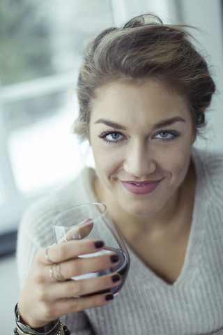 Porträt einer lächelnden jungen Frau mit einem Glas Kaffee, lizenzfreies Stockfoto