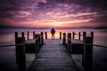 Italy, man standing on a jetty at sunset - SIPF01455